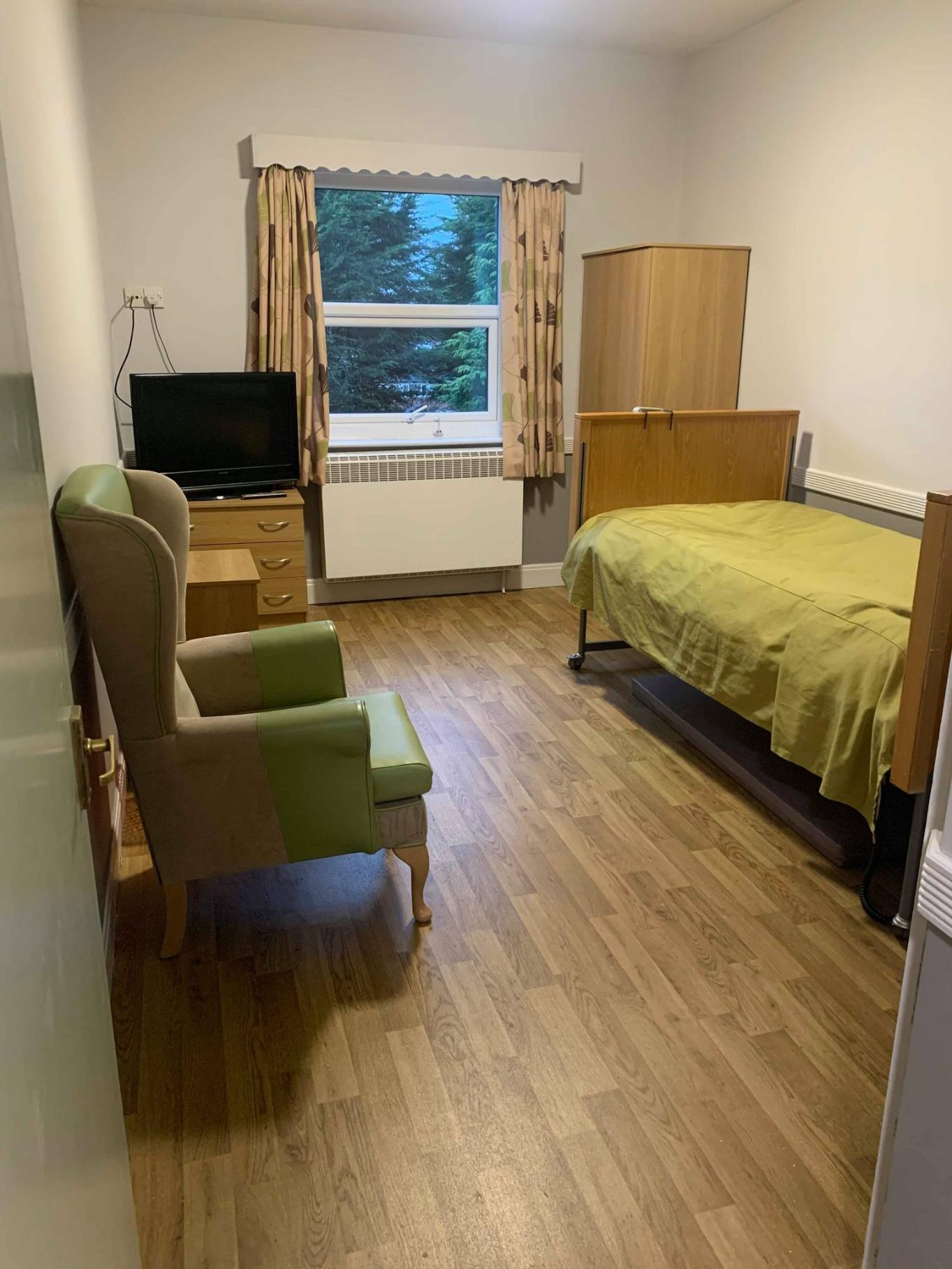 bedroom with green bedding and a green leather chair